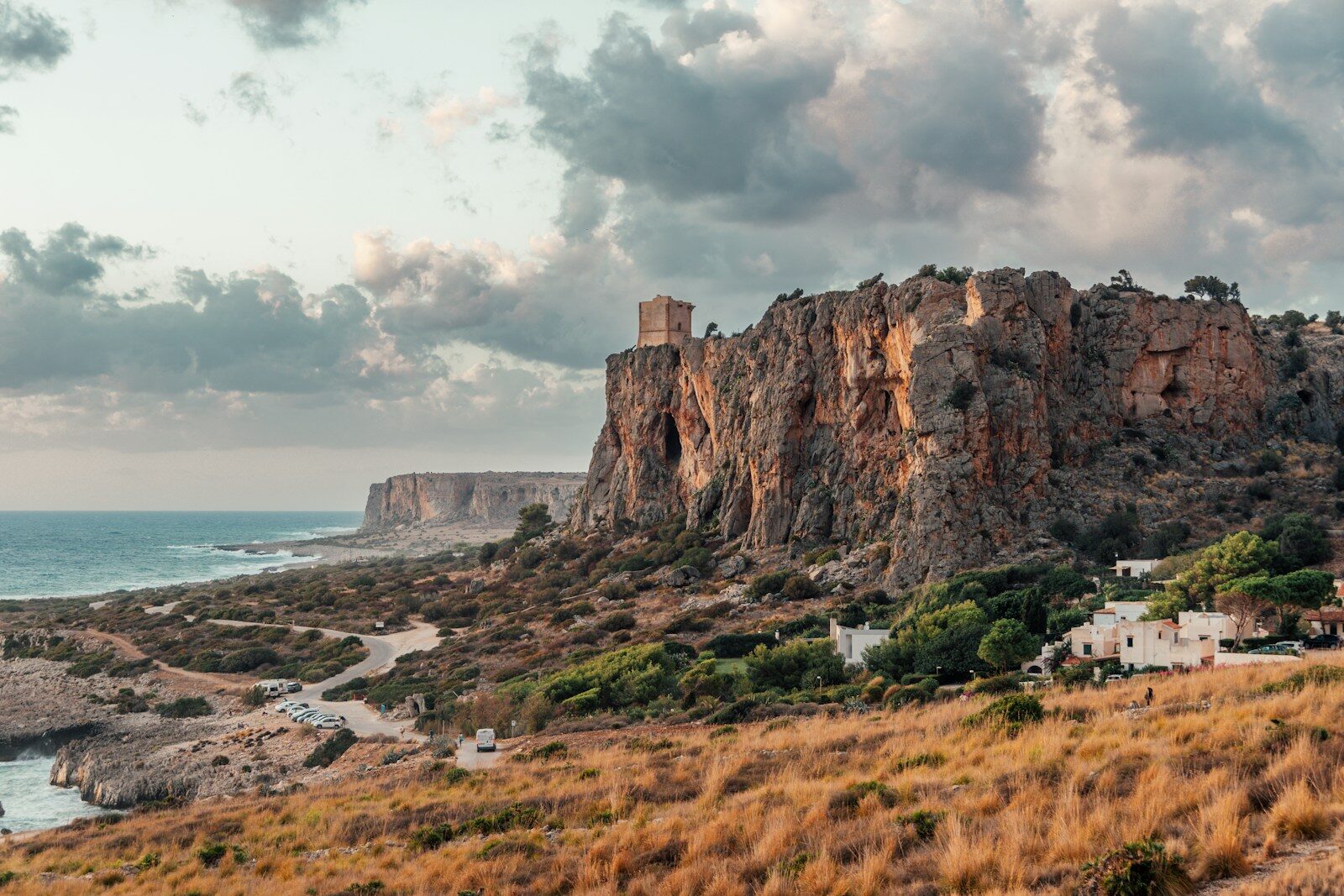 A view of a rocky cliff with a body of water in the background
